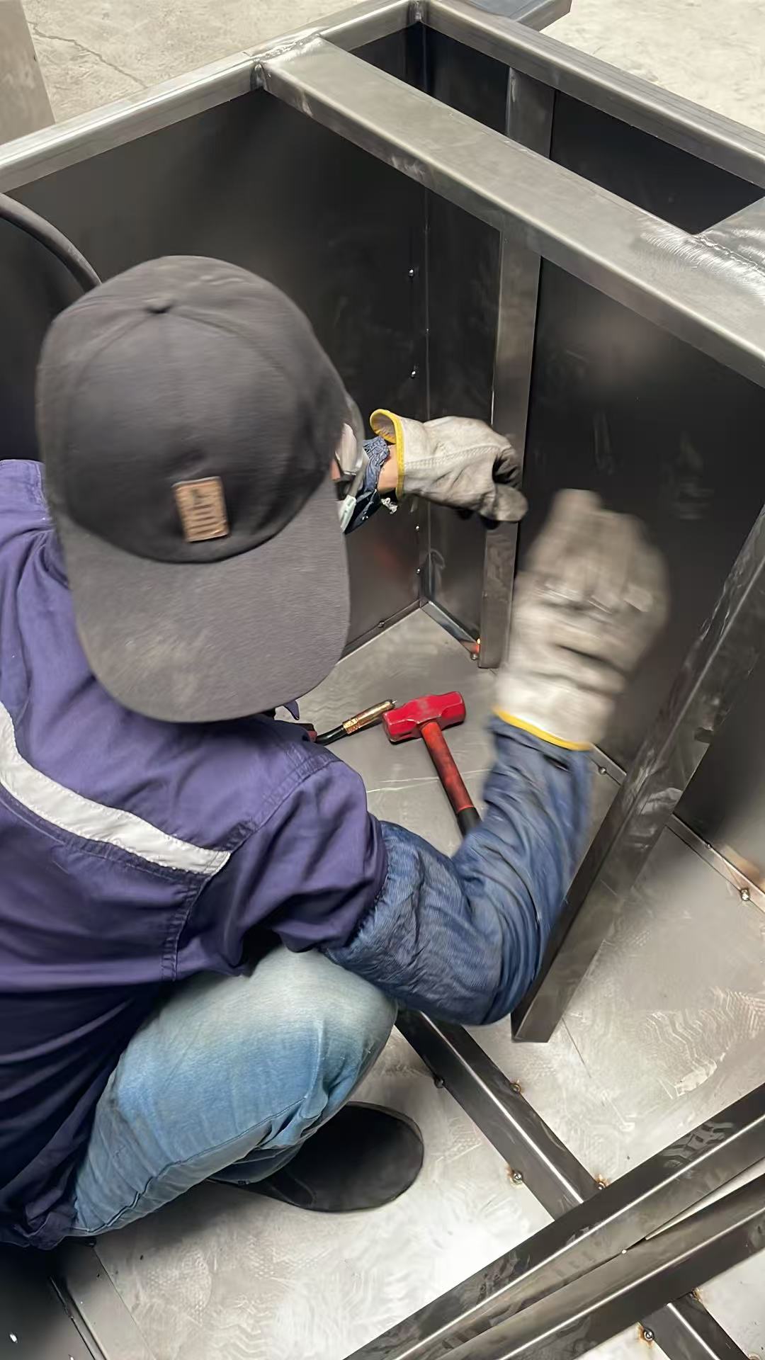 Worker fabricating the internal frame of a dust collector housing