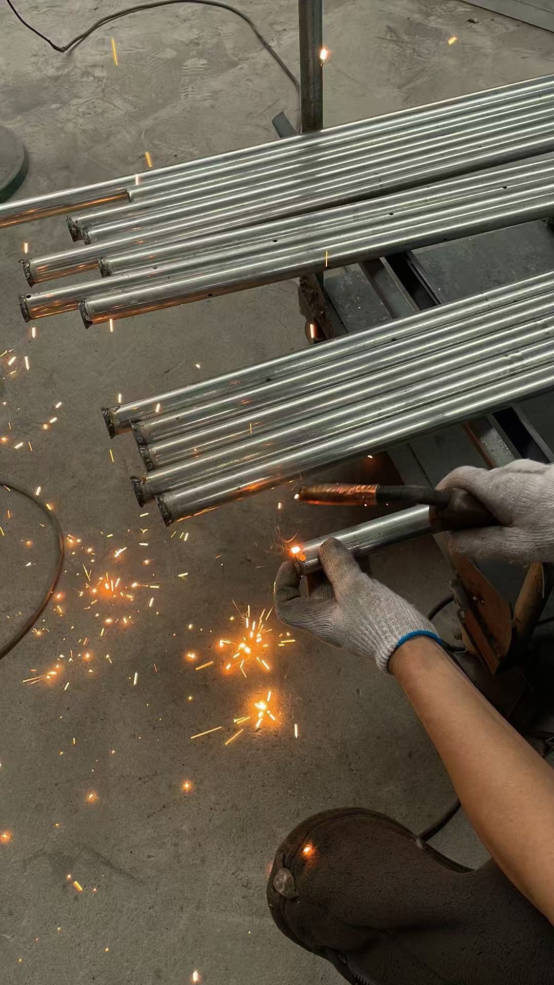 Worker welding a pulse jet blow pipe for a silo dust collector
